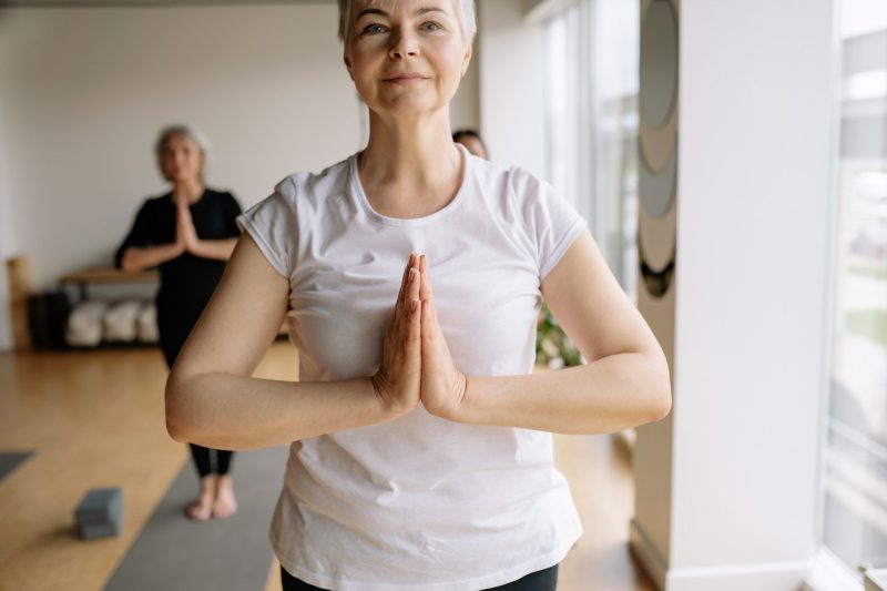 Older woman holding yoga pose.
