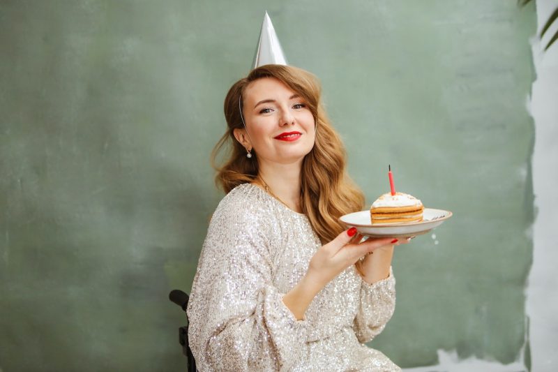 Woman holding slice of birthday cake on her 40th birthday.